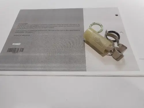 Remeha-Produkt zeigt einen Filter, der an einem grauen Hintergrund mit technischen Informationen platziert ist, daneben eine Klipsvorrichtung und ein Schlüsselring.